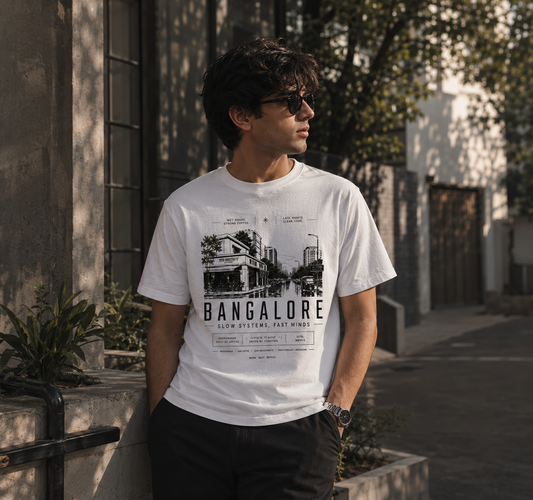 Man wearing a white t-shirt with 'Bangalore' design outdoors.