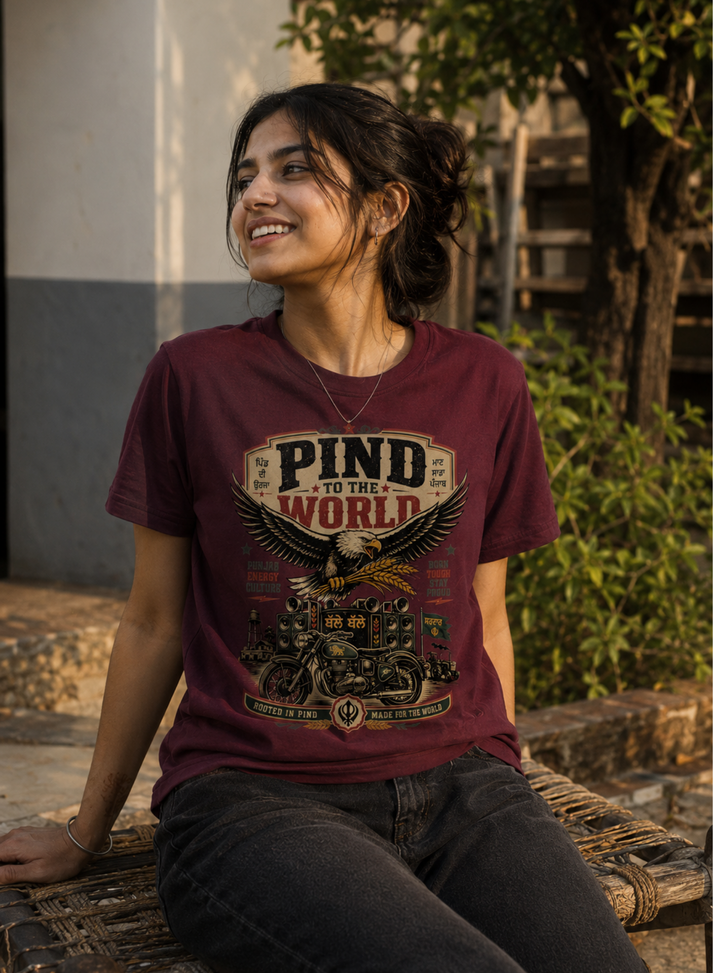 Woman with a 'PIND' (Punjab) design T-Shirt sitting with a scenic background